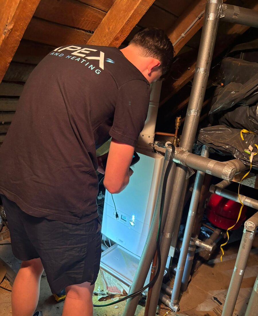 Apex engineer installing a new boiler in a loft space