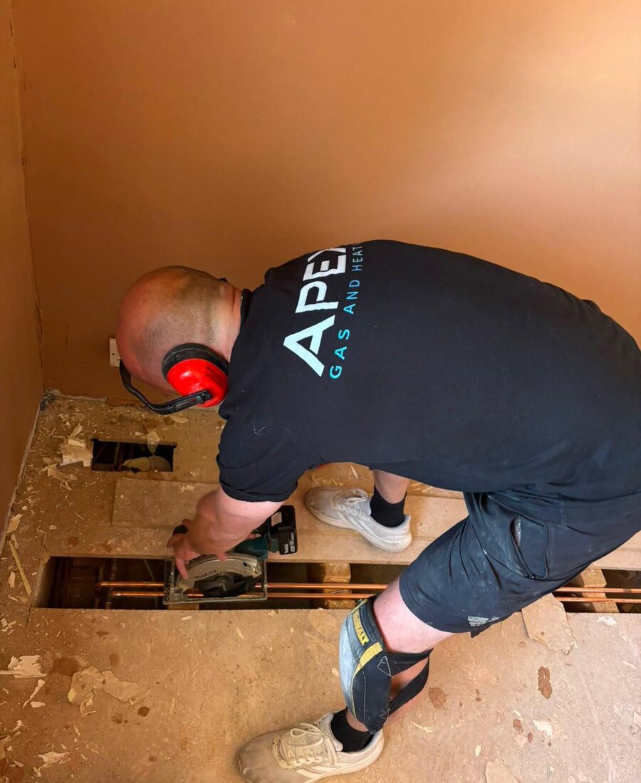 Apex engineer carrying out pipework under a floor